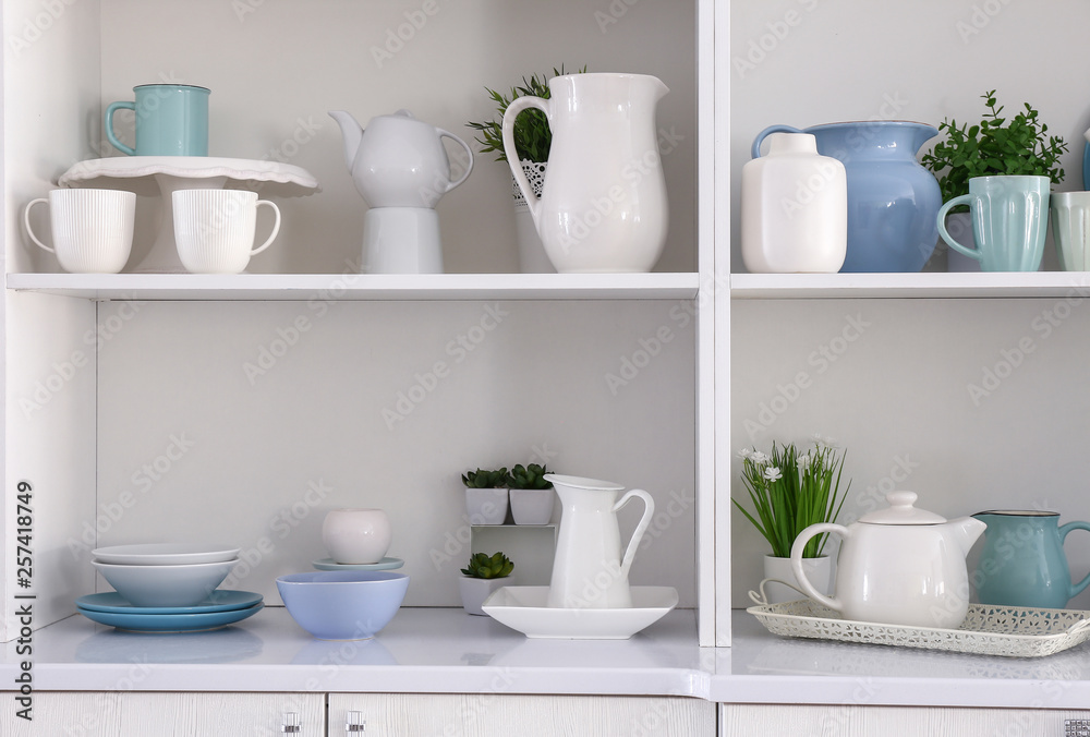 Open cupboard with clean dishes in kitchen