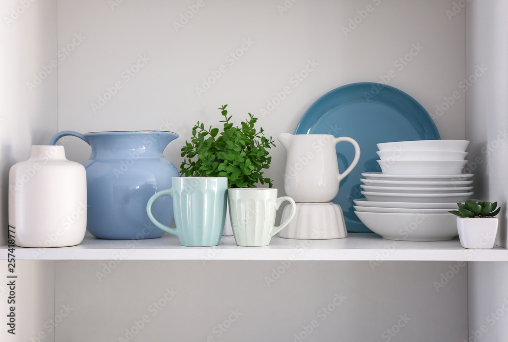 Shelf with clean dishes in kitchen