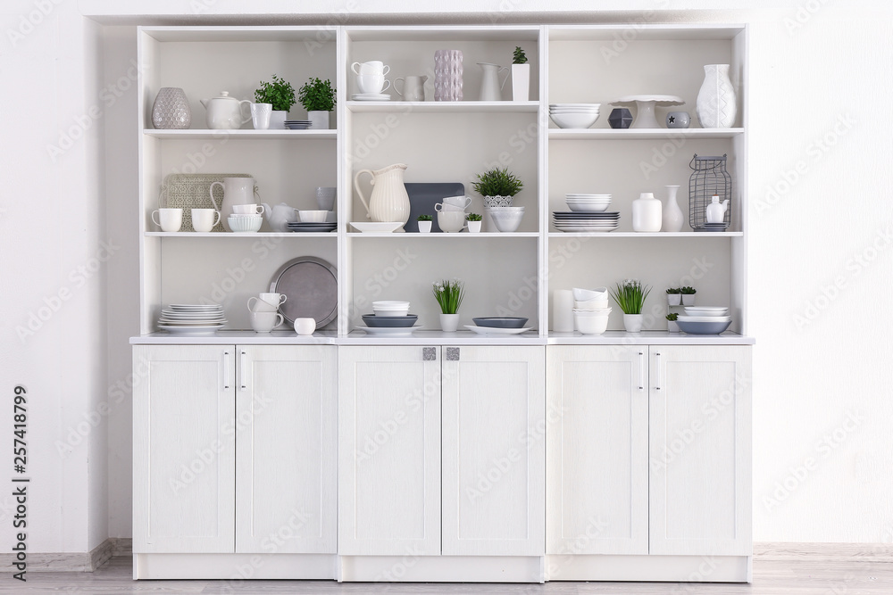 Open cupboard with clean dishes in kitchen