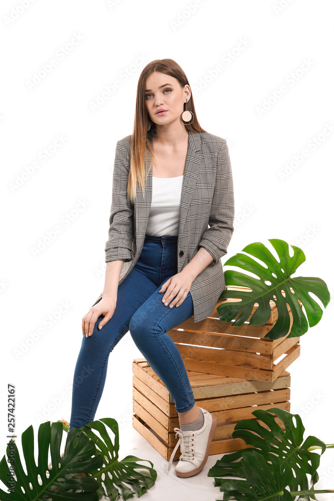 Portrait of beautiful woman with green tropical leaves on white background