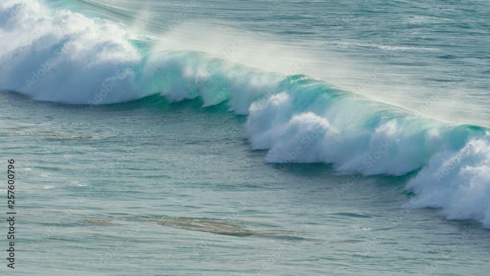 Crystal clear smooth waves slowly approaching empty coast from a great distance.