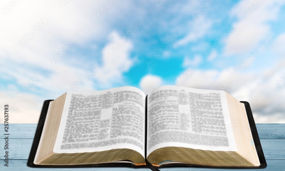 Open book on old wooden table.