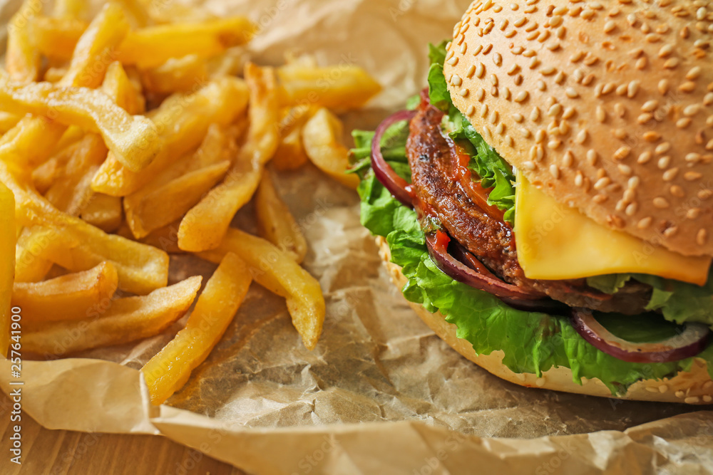 Tasty fresh burger and french fries on table, closeup