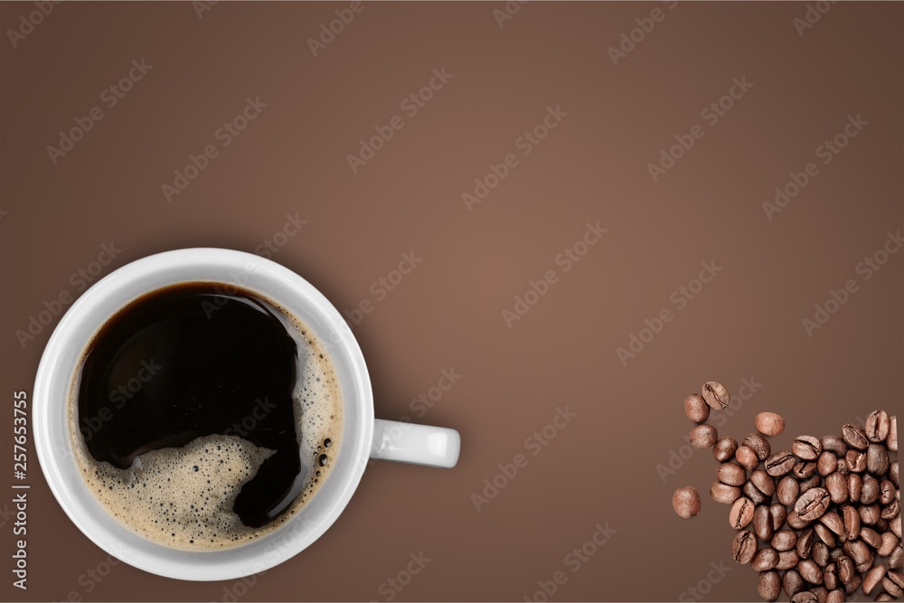 Cup of hot coffee with beans, top view