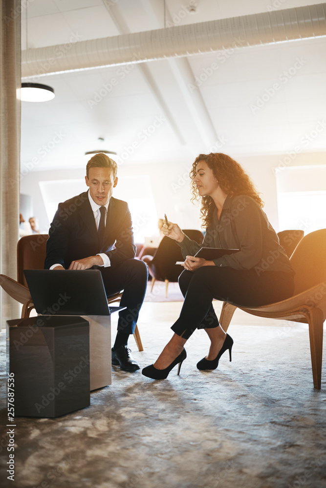 Two businesspeople working together online with a laptop