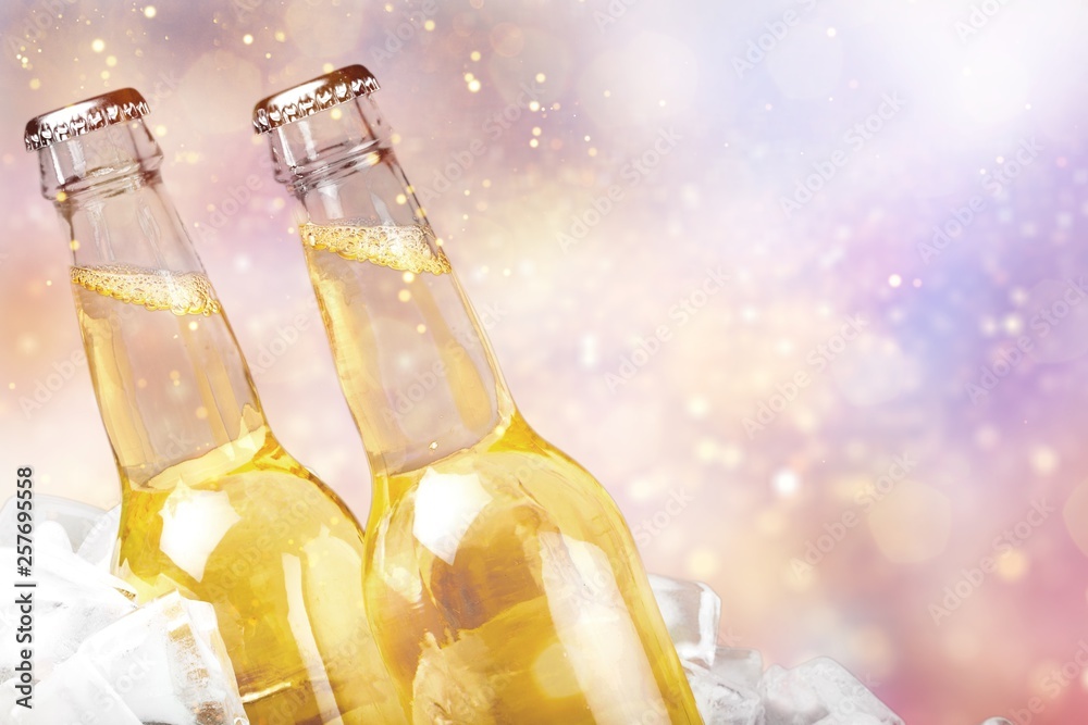 Beer bottles with ice on light background