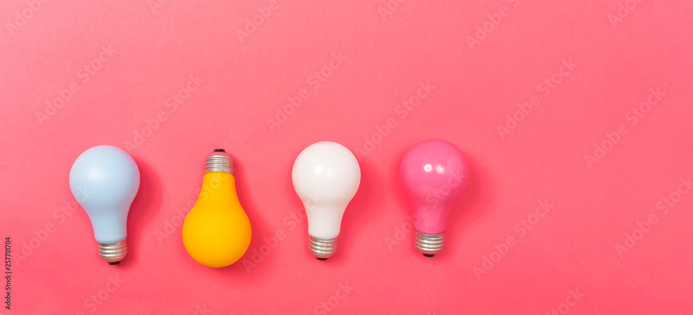 Colored light bulbs on a pink paper background