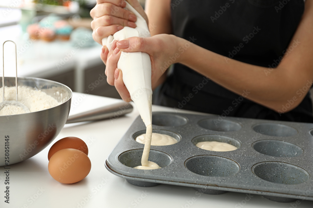 年轻女性糖果师在厨房烹饪松饼