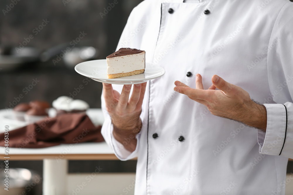 Male confectioner with piece of tasty cake in kitchen