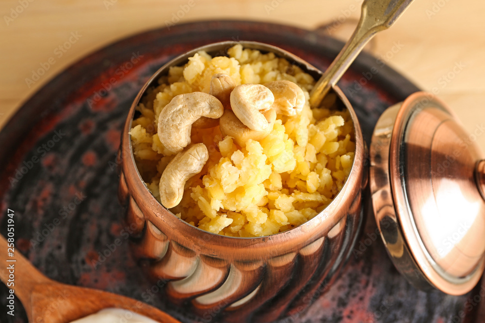 Bowl with traditional Indian food pongal on table, closeup