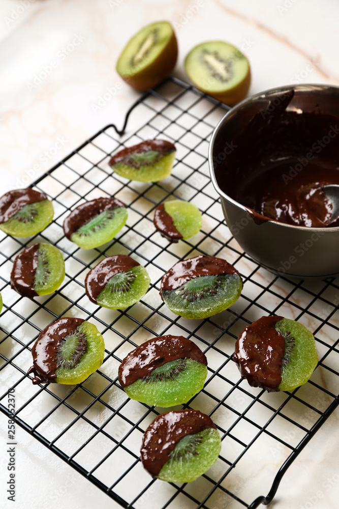 Tasty chocolate covered kiwi on light table