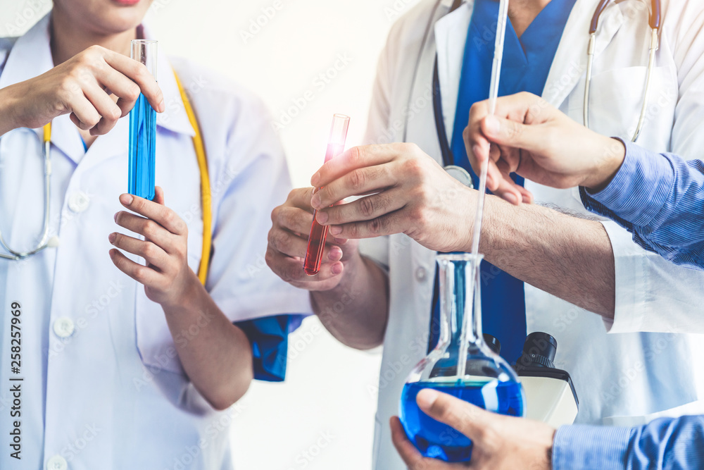 Group of scientists wearing lab coat working in laboratory while examining biochemistry sample in te