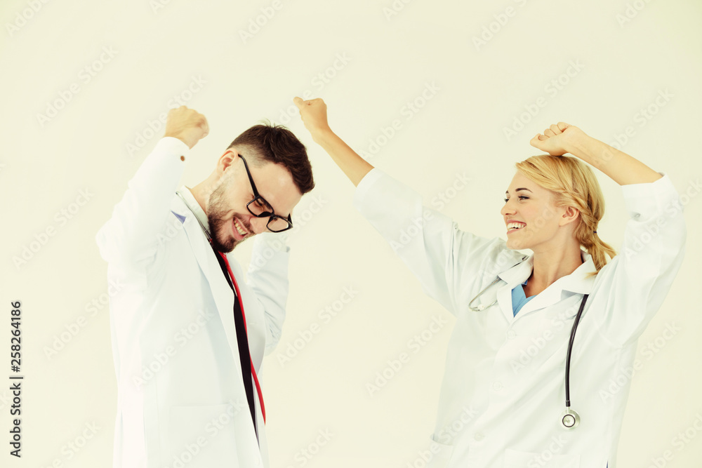 Happy successful doctor celebrates victory in hospital office with another doctor standing beside he