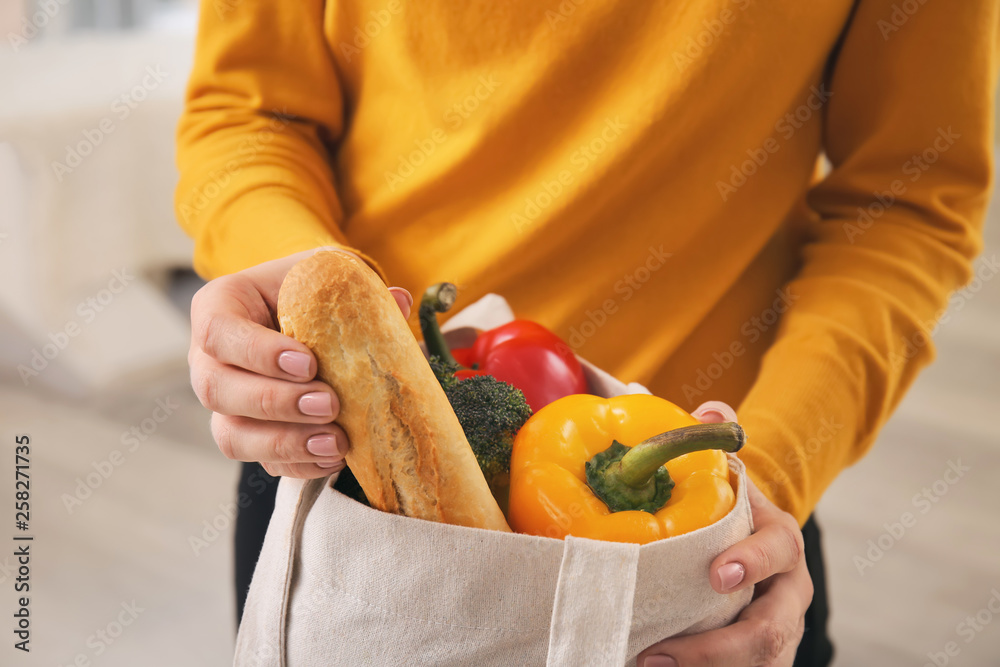 Young woman with fresh products in eco bag, closeup