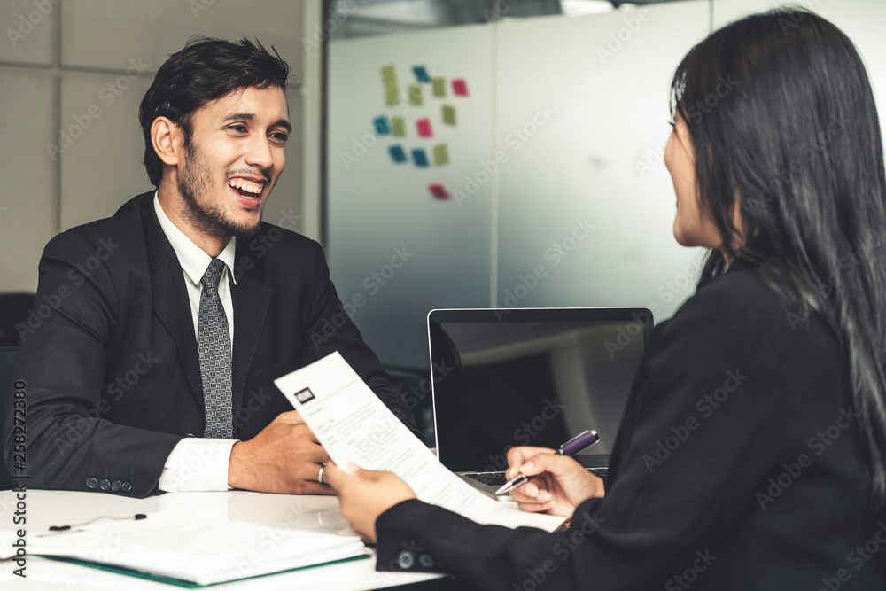 Human resource manager interviewing the male employment candidate in the office room. Happy job inte