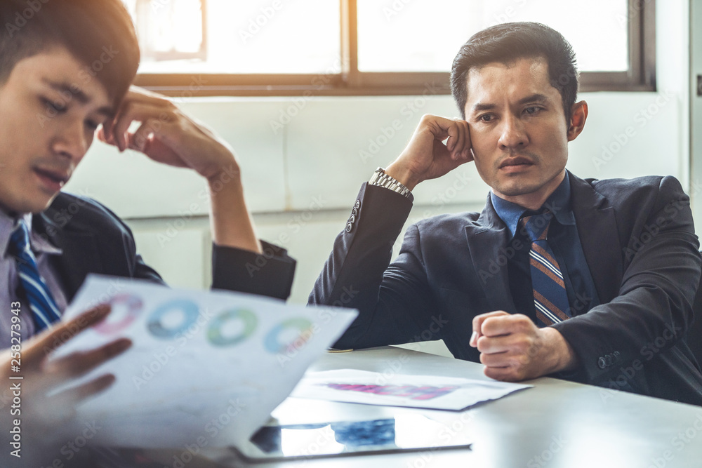 Unhappy business manager and young businessman partner in meeting room at the office. They are under