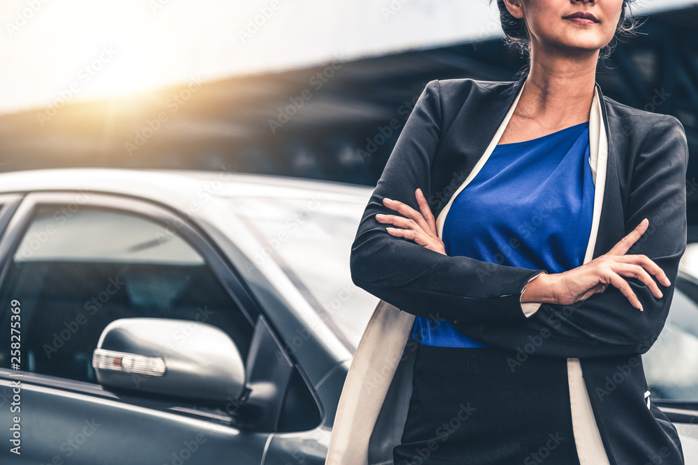 Confident professional business woman standing beside the car. Concept of car rental business and sa