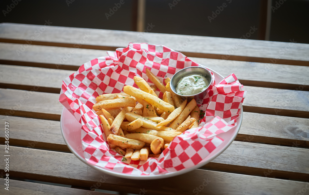 French fries with sauce on wooden table