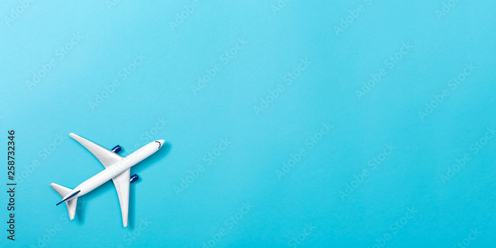 A toy airplane on a blue paper background