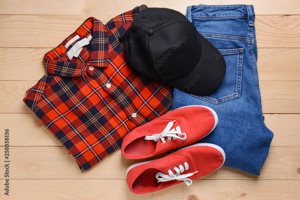 Clothes with cap on wooden background