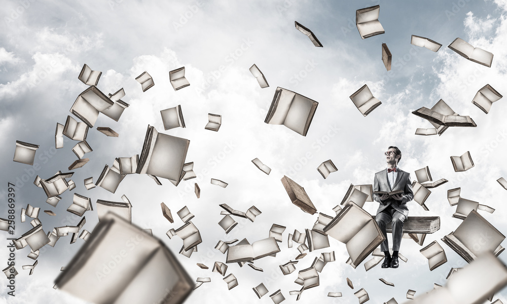 Young businessman or student studying the science and books fly around