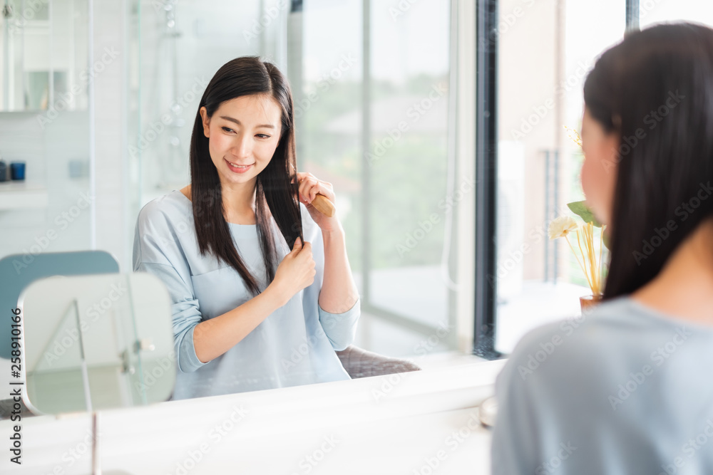 亚洲美女在镜子前梳头