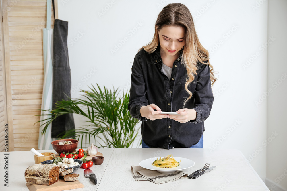 女美食摄影师拿着手机在家拍美食