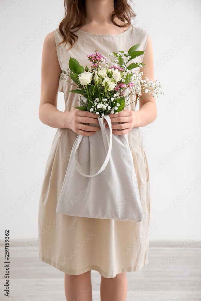 室内环保袋里装着一束鲜花的年轻女子