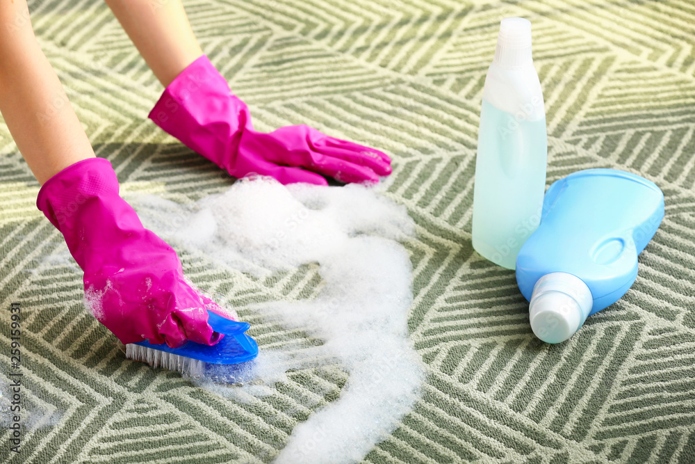 Woman cleaning carpet at home