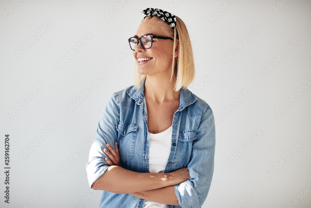 Laughing young female entrepreneur wearing glasses against a whi