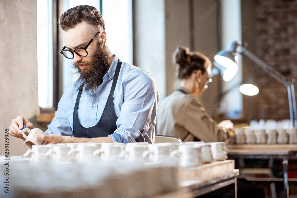 Man and woman working in the pottery shop