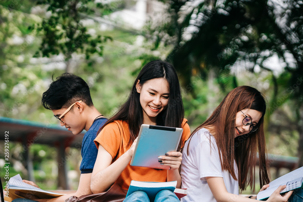 A group of young or teen Asian student in university smiling and reading the book and look at the ta