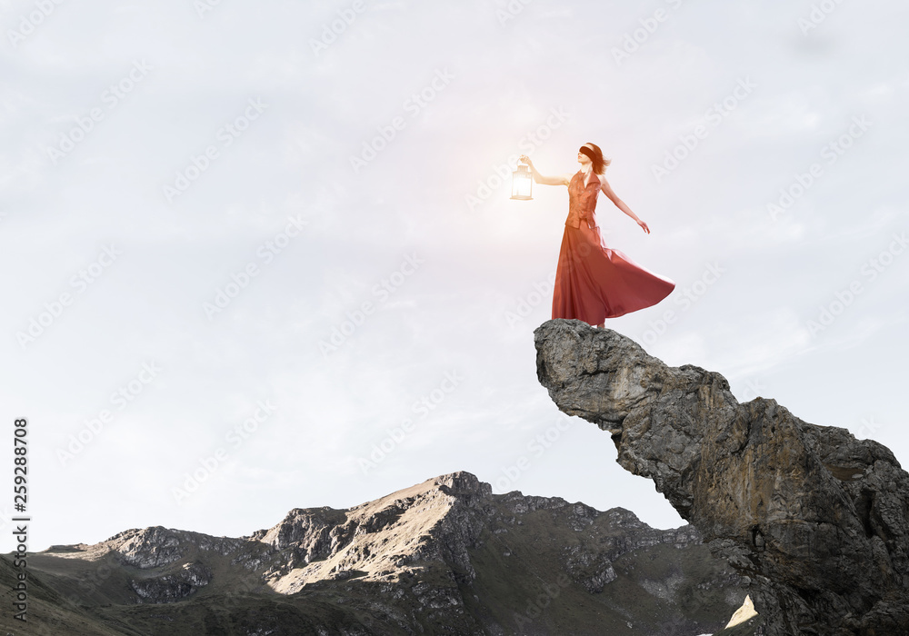 Attractive girl muse with old lantern in hand at summer day