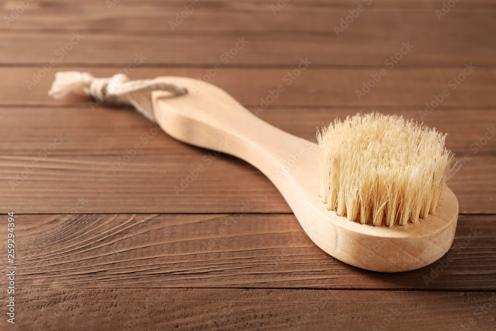 Massage brush on wooden background