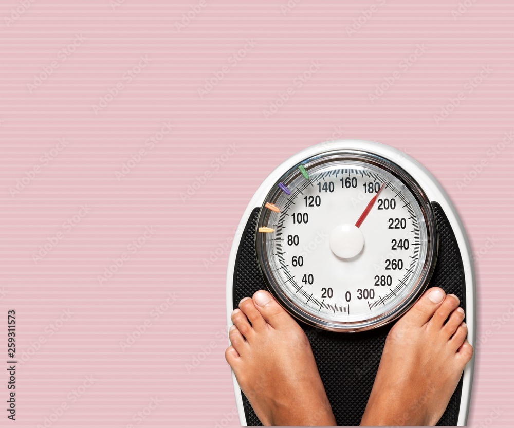 Female legs on scales on background