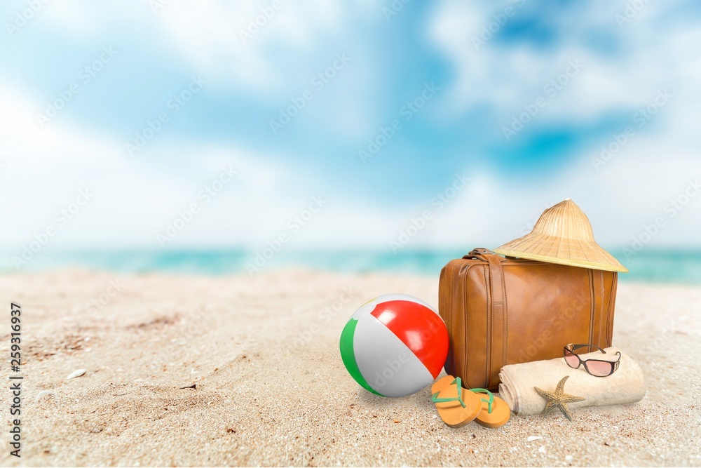 Straw hat, bag,  flip flops on a tropical beach