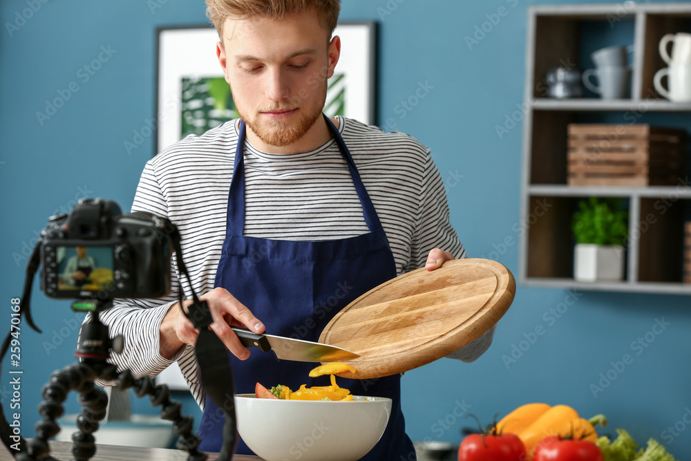 年轻男性美食博主在厨房录制视频