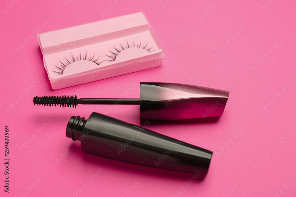 Mascara with false eyelashes on color background