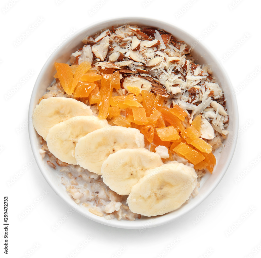 Bowl with tasty sweet oatmeal on white background