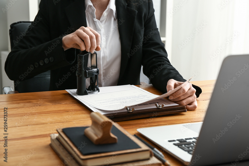 Notary public stamping document in office