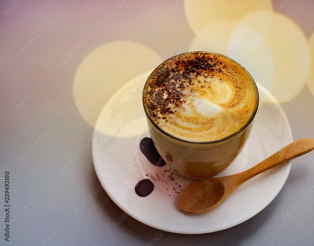 Hot latte coffee on the table with blurred bokeh background.