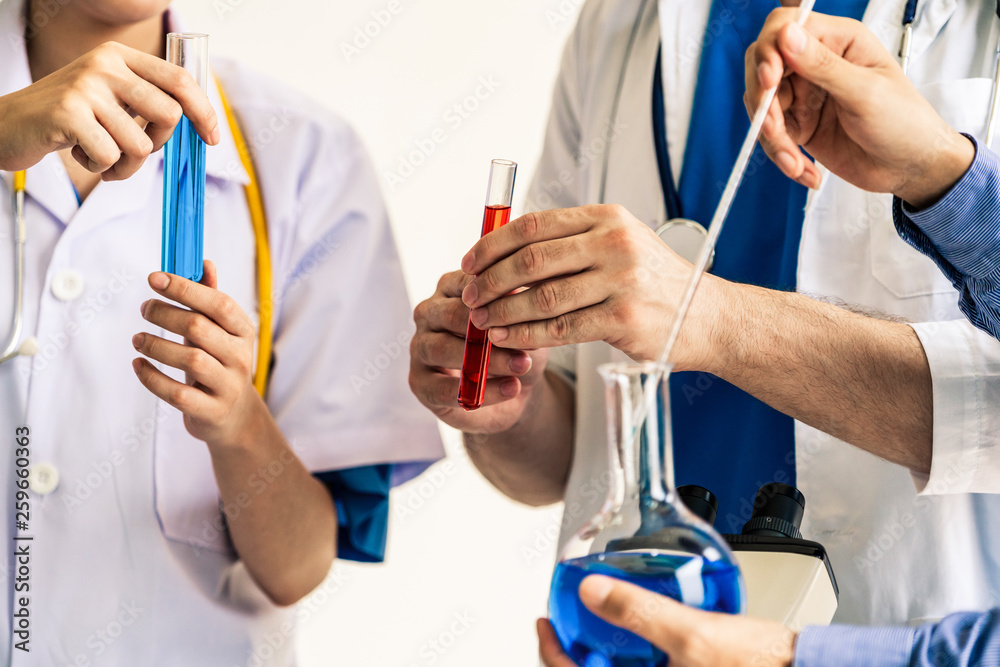 Group of scientists wearing lab coat working in laboratory while examining biochemistry sample in te