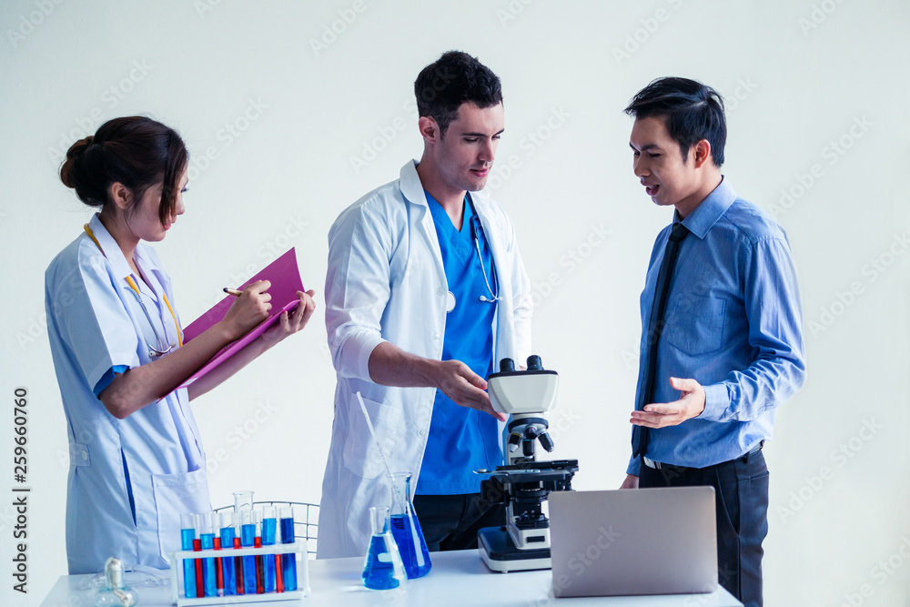 Group of scientists wearing lab coat working in laboratory while examining biochemistry sample in te