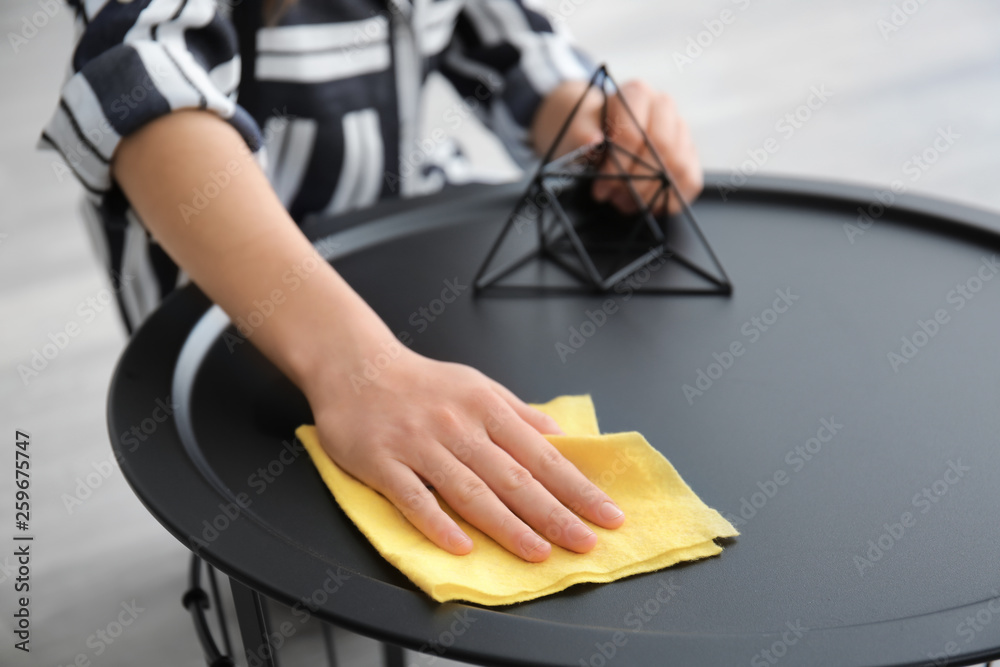 Woman cleaning table in room