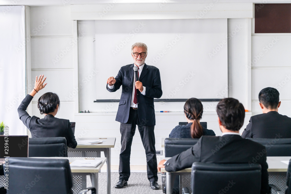 Senior leader speaker speaks to public people audience in training workshop or conference. Mature le