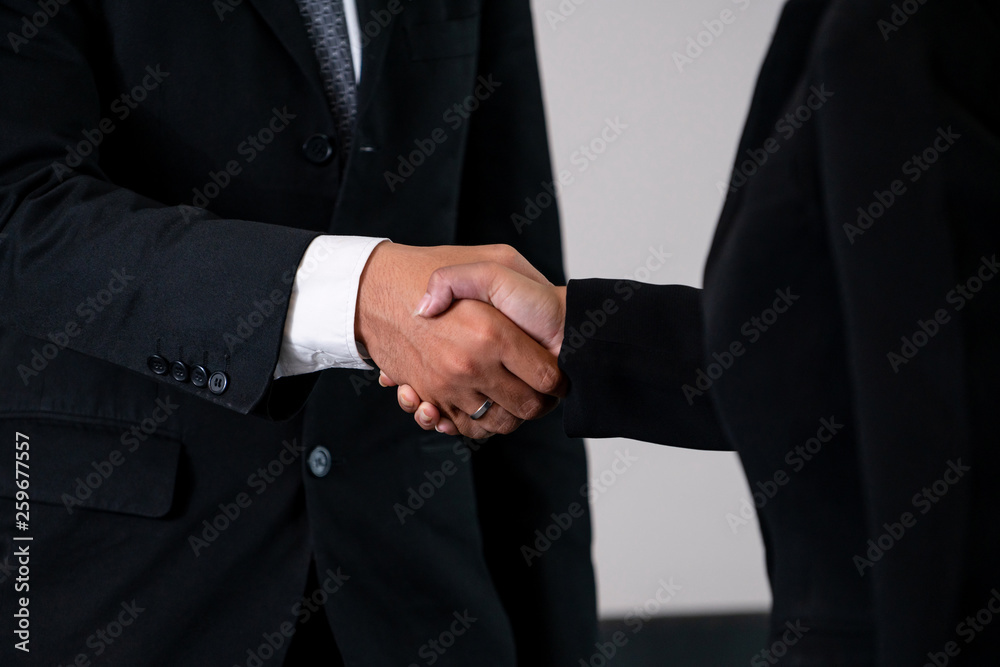 Business people agreement concept. Businessman and Asian businesswoman do handshake in the office.