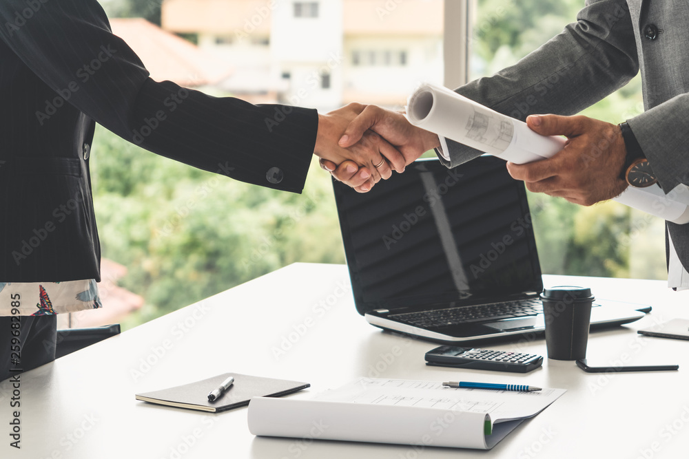 Businessman executive handshake with businesswoman worker in modern workplace office. People corpora