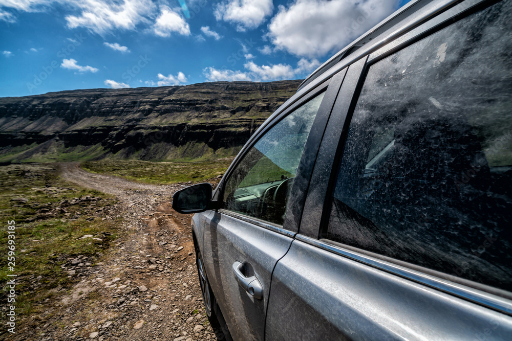 4WD SUV vehicle car running on gravel road with nature mountain landscape in Iceland. Adventure and 