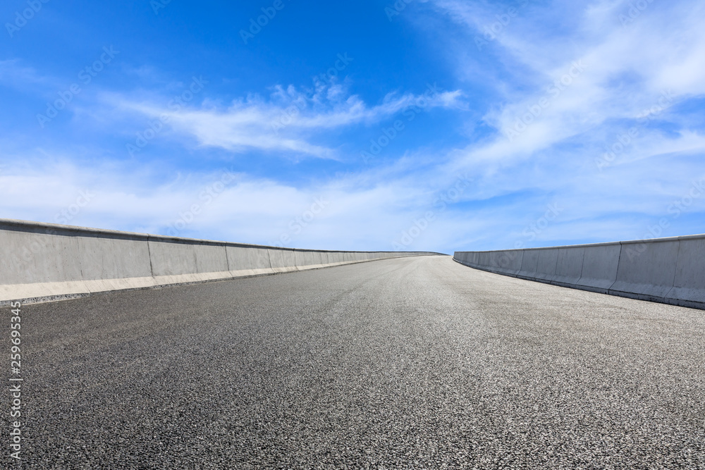 Empty asphalt road and blue sky with white clouds scene