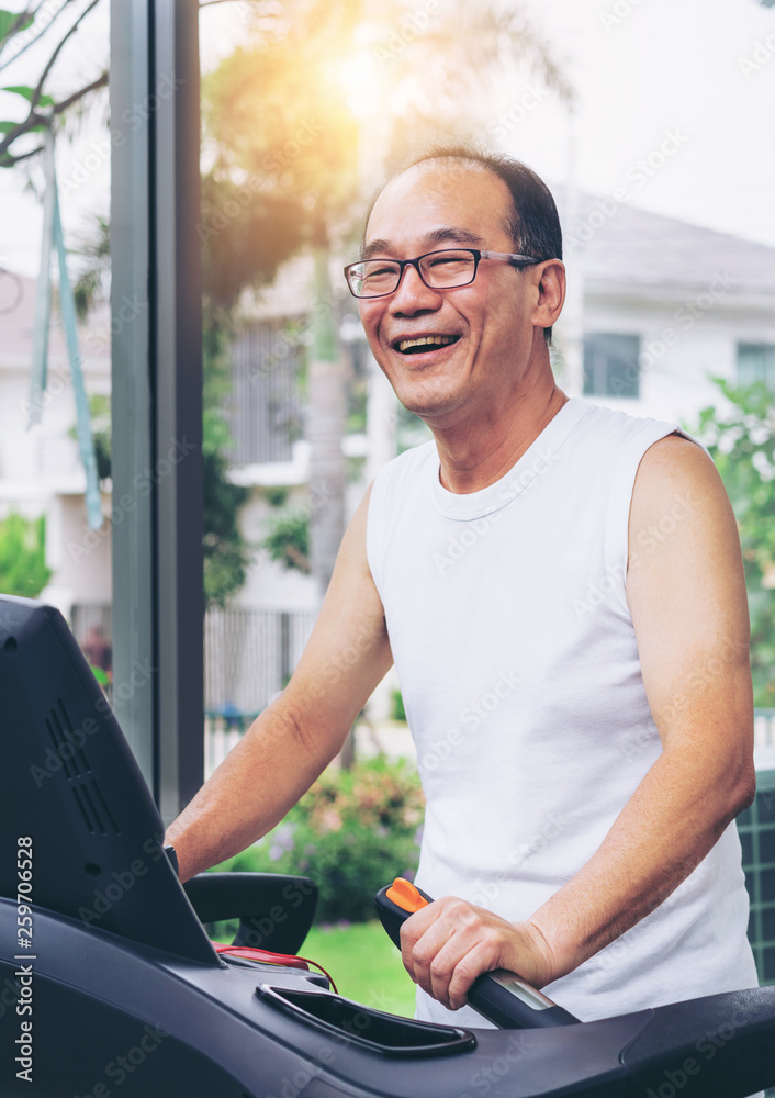 Senior man exercise on treadmill in fitness center. Mature healthy lifestyle.